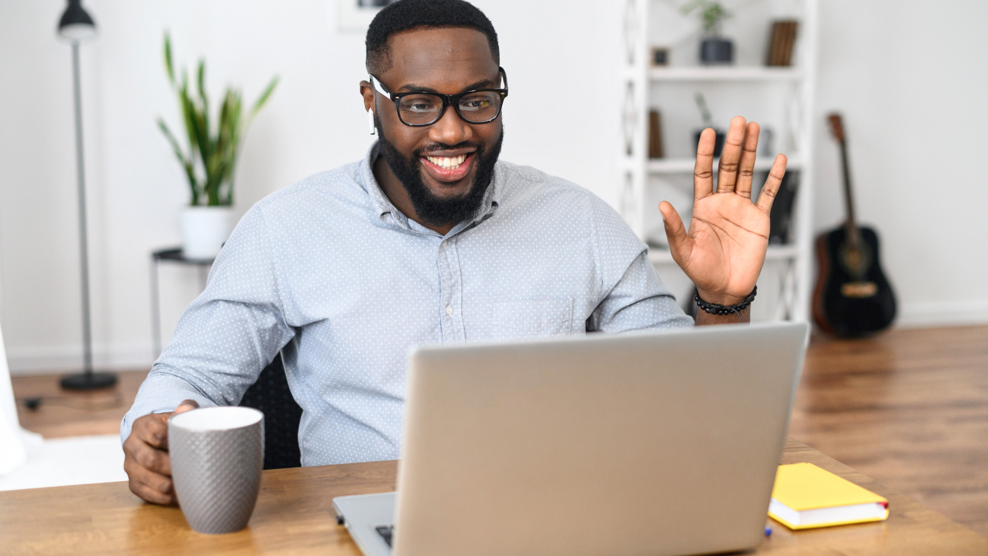 coach waving sitting at computer